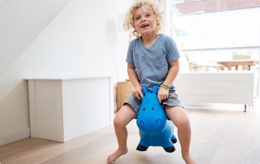 Kind springt met blauw speelgoed